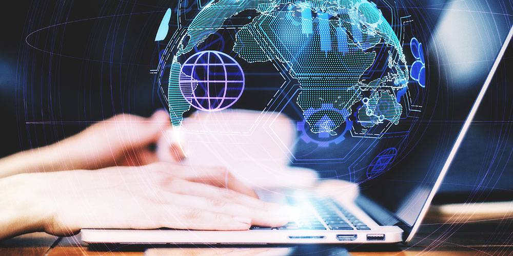 Hands typing on a laptop keyboard with a digital illustration of a world map and data graphics overlayed in the background.