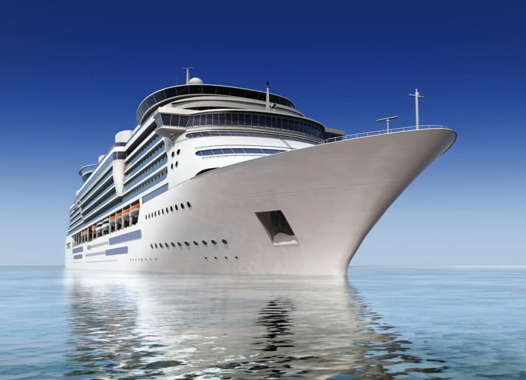A large white cruise ship sails calmly on clear blue water under a cloudless sky, viewed from a low angle near the bow.