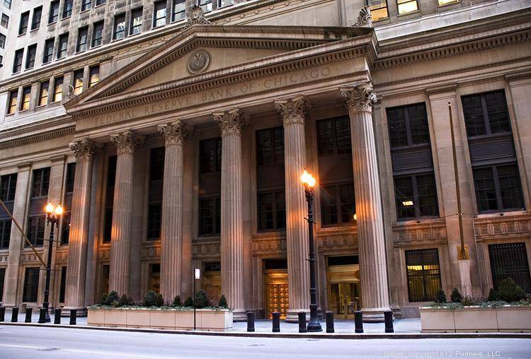 The facade of the Federal Reserve Bank of Chicago, featuring tall columns and classical architecture, viewed from across the street.